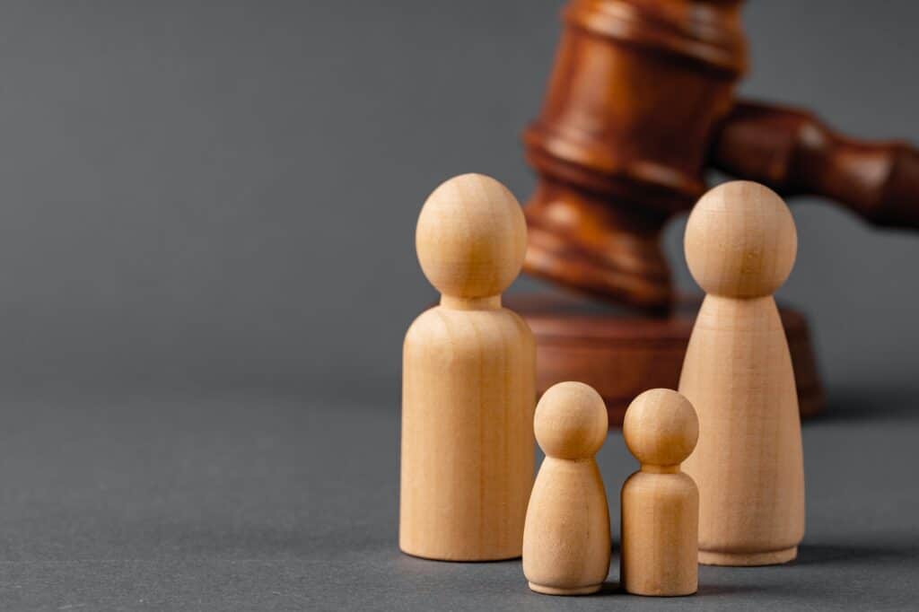 Wooden toy family and judge mallet. Family divorce concept